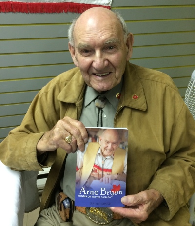 Arne Bryan holding the story of his life. Photo by Rev. Ed Hird.