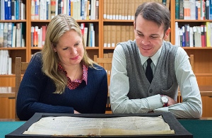 UBC’s Katherine Kalsbeek and Richard Pollard admire the Papal bull acquired by UBC Library. The document was written in 1245. Credit: Don Erhardt