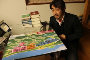 Pastor Ikarashi with a proposed new community design for Usuiso.