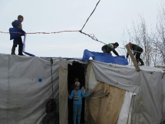 Tent repairs after a storm in the Bekaa Valley. Photo by James Grunau.